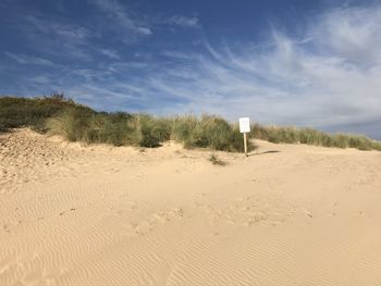 Scenic view of sand dunes against sky