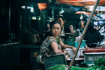 Portrait of young woman sitting outdoors
