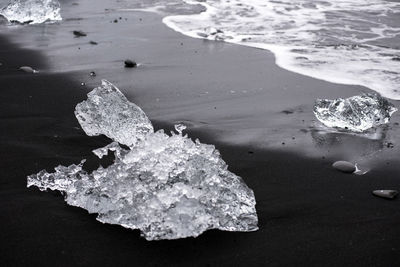 Ice blocks on diamond  beach, sea waves, black sand. jokulsarlon. atlantic ocean coast, iceland