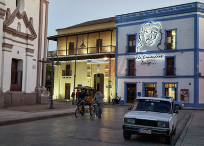 People on street against building in city