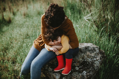 Full length of mother and woman sitting on bench