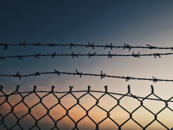 Low angle view of chainlink fence against clear sky