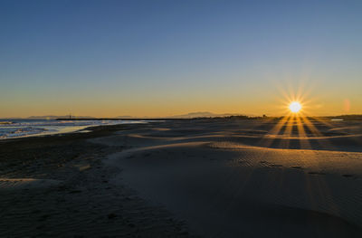 Scenic view of beach against sky during sunset