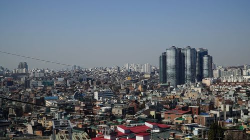 Aerial view of modern buildings in city against clear sky