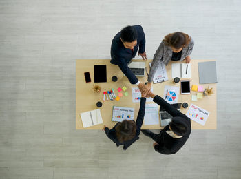 High angle view of man holding cat on floor