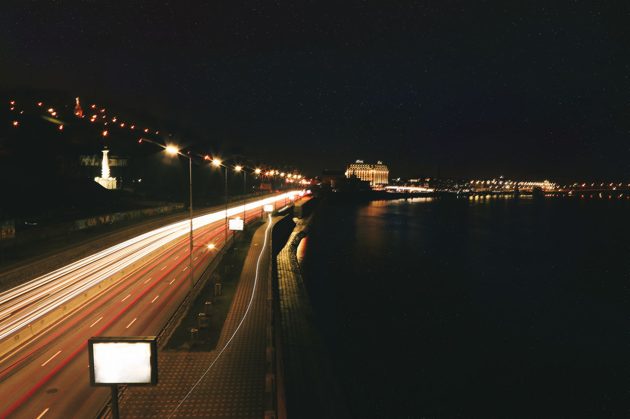 LIGHT TRAILS ON CITY STREET AT NIGHT