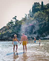 People enjoying in water against sky