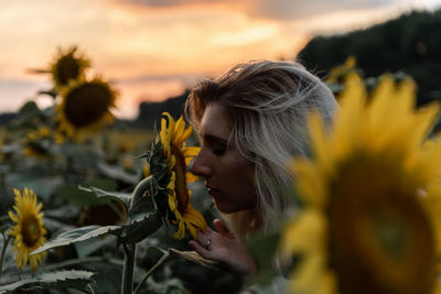 Close-up of woman smelling sunflower