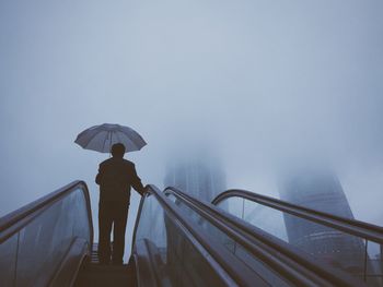 Rear view of man on escalator