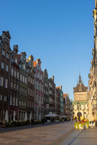 Buildings in city against clear blue sky