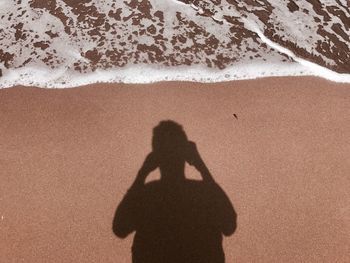 Shadow of man on sand at beach