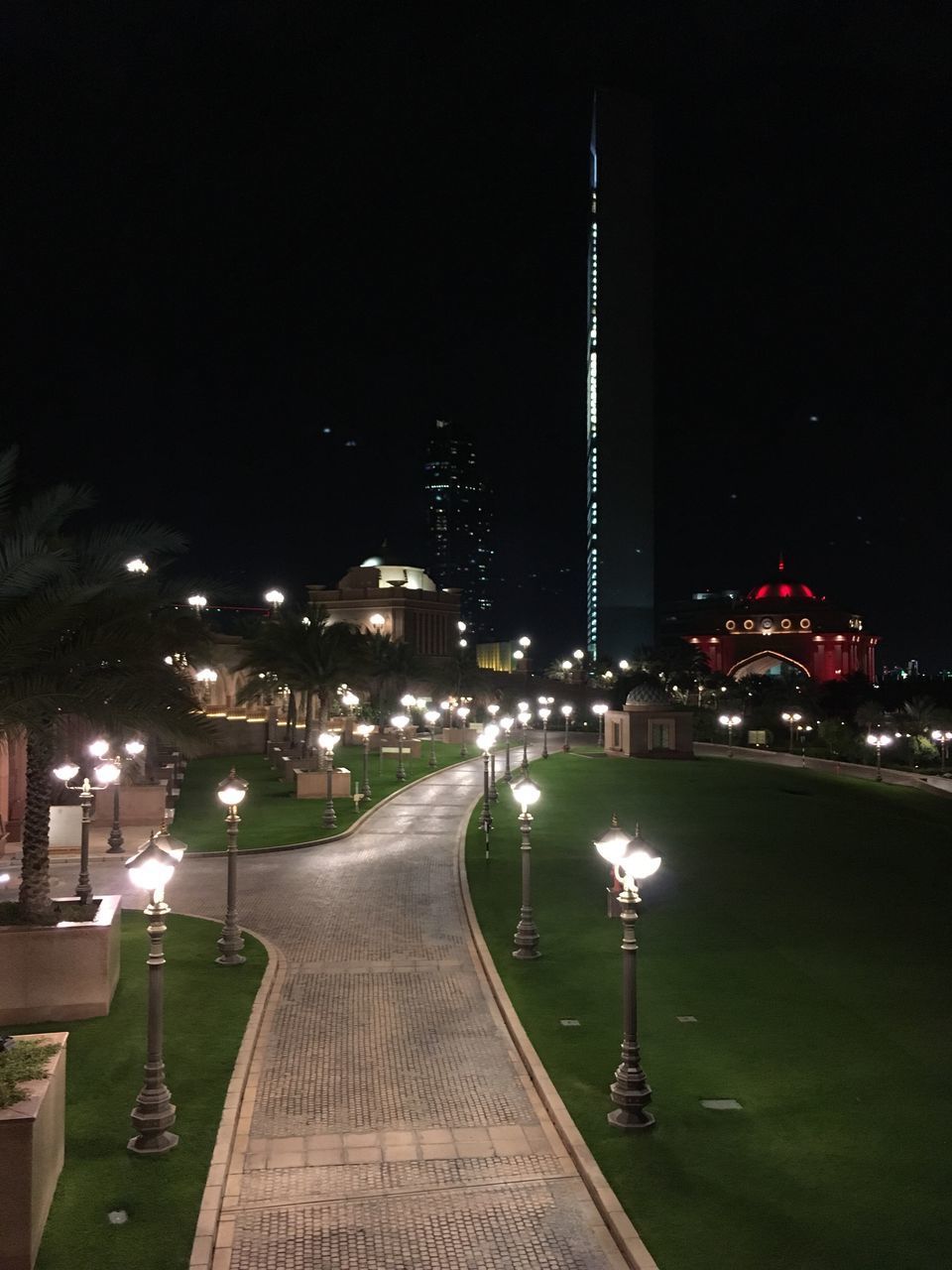 ILLUMINATED STREET AMIDST BUILDINGS AT NIGHT