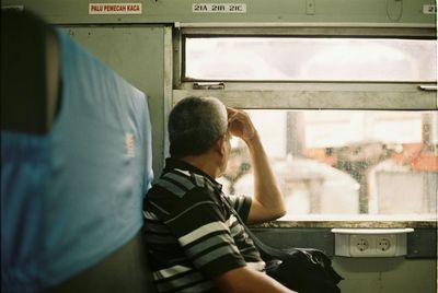 Rear view of man sitting in train