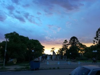 Road in city against sky during sunset