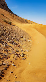 Sand dunes in desert against sky