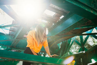 Low angle view of woman standing by built structure