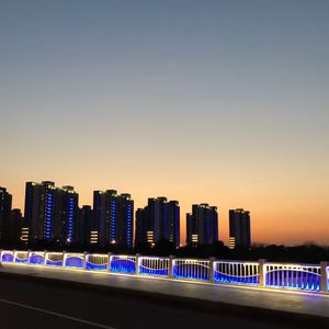 Illuminated city against clear sky at night