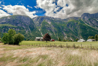 Scenic view of field and mountains against sky