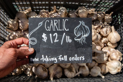 Text on hand holding food at market stall