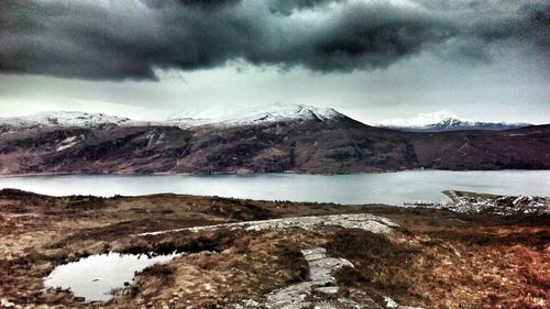 Scenic view of lake against cloudy sky