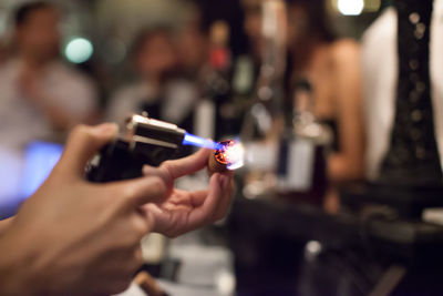 Hands of woman burning cigar with lighter