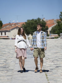 Full length of women walking on footpath