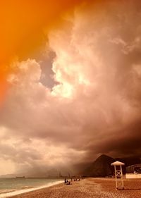 Scenic view of beach against cloudy sky