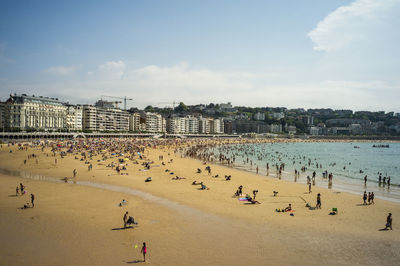 Group of people on beach against sky