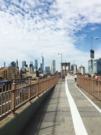 People on brooklyn bridge against city skyline