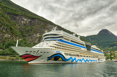 Scenic view of river by mountains against sky