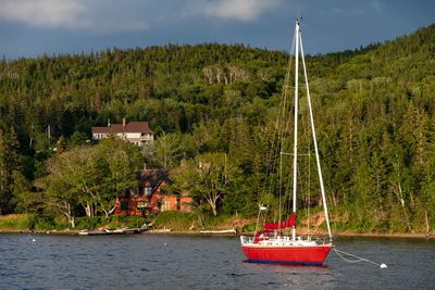 Sailboat on sea by building against sky