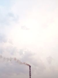 Low angle view of smoke emitting from chimney against sky