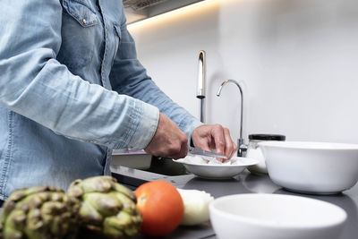 Midsection of man preparing food in kitchen at home