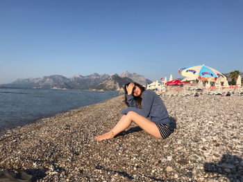 Woman on beach against clear sky