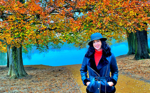 Woman standing by tree during autumn