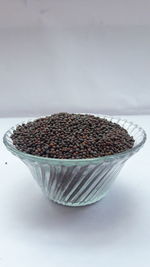 Close-up of bread in bowl on table against white background