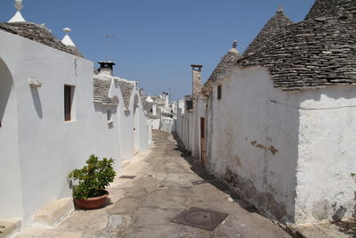 Alley amidst buildings in city against clear sky
