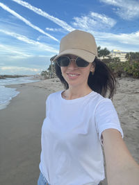 Portrait of young woman standing at beach