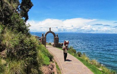 Rear view of women by sea against sky