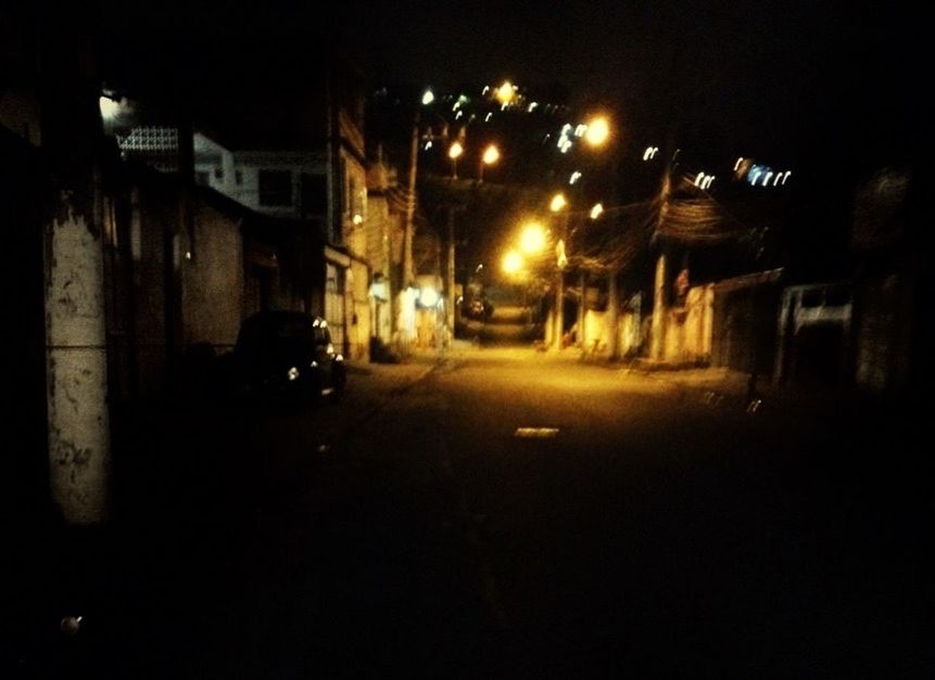 EMPTY ROAD ALONG ILLUMINATED BUILDINGS