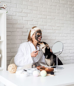 Self care. young caucasian woman wearing bathrobes doing spa procedures with her dog