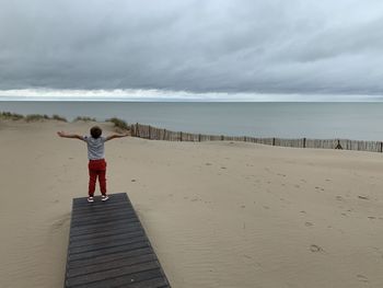 Rear view of boy standing on beach