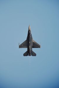 Low angle view of airplane flying against clear blue sky
