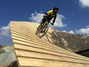 Low angle view of man riding motorcycle against sky