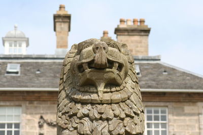 Low angle view of statue against historic building against sky