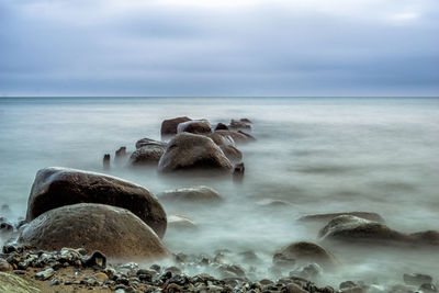 Rocks on beach against sky