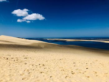 Scenic view of beach against blue sky