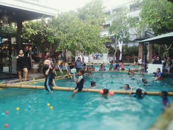 People in swimming pool against trees