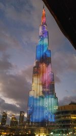 Low angle view of illuminated building against cloudy sky