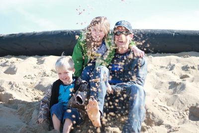 Full length of happy boy with dog on beach